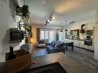 a living room and kitchen with a couch and a table at Relax & Explore Stylish Apartment in Rome in Rome