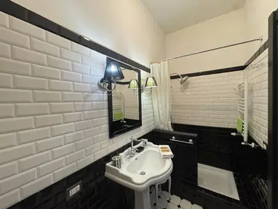 a white bathroom with a sink and a mirror at Relax & Explore Stylish Apartment in Rome in Rome