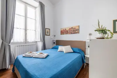 a bedroom with a blue bed with towels on it at Monti apartment in Rome