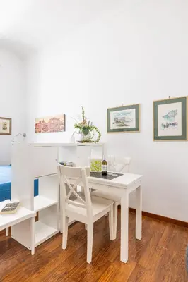 a white dining room with a white table and chairs at Monti apartment in Rome