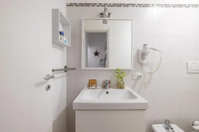 a white bathroom with a sink and a mirror at Monti apartment in Rome