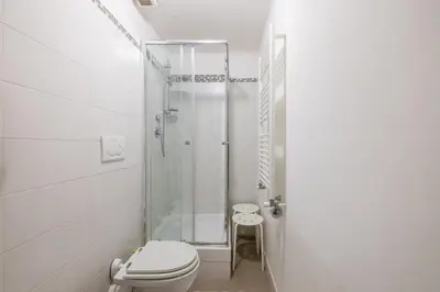 a white bathroom with a toilet and a shower at Monti apartment in Rome