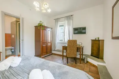 a bedroom with a bed and a desk and a table at BB Trastevere Station - Room1 in Rome