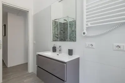 a white bathroom with a sink and a mirror at Domus Ponte Lungo in Rome