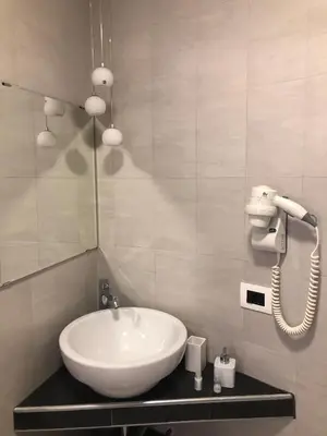 a bathroom with a white sink and a phone at Maison Maneli in Rome