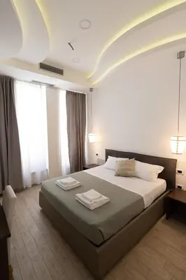 a bedroom with a large bed with two towels on it at Maison Maneli in Rome