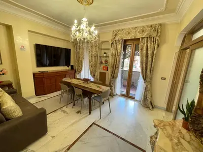 a living room with a table and a chandelier at Family Suite Santamaria in Rome