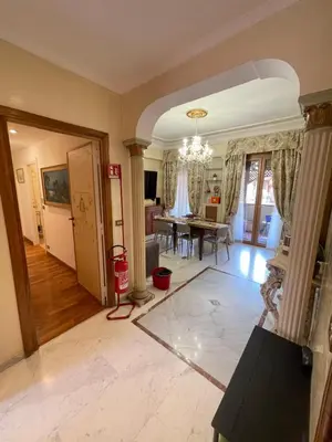 a living room with a chandelier and a dining room at Family Suite Santamaria in Rome