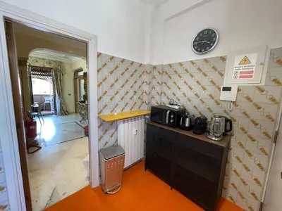 a kitchen with a counter and a clock on the wall at Family Suite Santamaria in Rome