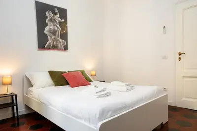 a white bed in a room with a picture on the wall at Fernando’s Apartment in Rome