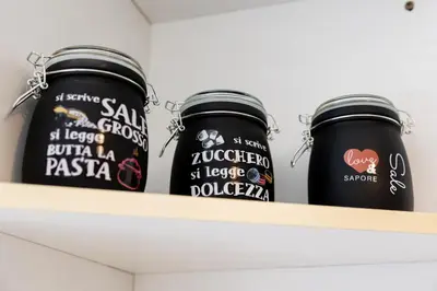three black jars sitting on a shelf at Fernando’s Apartment in Rome