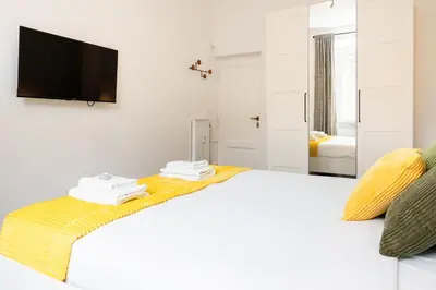 a kitchen with white cabinets and a table and a window at Fernando’s Apartment in Rome