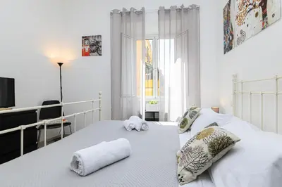 a white bedroom with a bed with towels on it at Sanniti Luigi Cozy Home in Rome