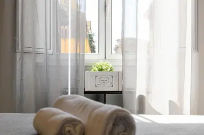 a bed with a blanket and a window with a plant at Sanniti Luigi Cozy Home in Rome