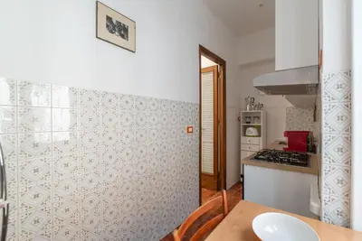 a small kitchen with a table and a stove at GuestHost - Bright Apartment X4 along the Tevere! in Rome