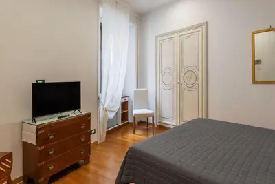 a bedroom with a bed and a dresser with a television at GuestHost - Bright Apartment X4 along the Tevere! in Rome