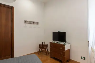 a bedroom with a bed and a tv on a dresser at GuestHost - Bright Apartment X4 along the Tevere! in Rome