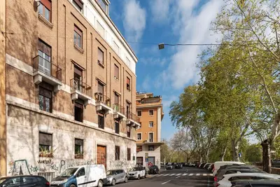 a street with cars parked next to a building at GuestHost - Bright Apartment X4 along the Tevere! in Rome