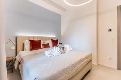 a bedroom with a large white bed with red pillows at EP2000 Roman Holidays in Rome