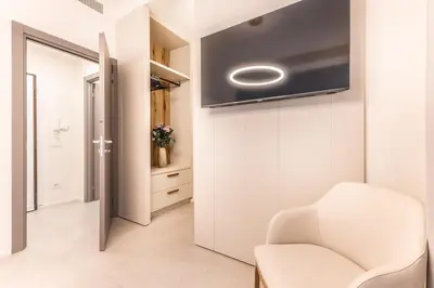 a living room with a white chair and a tv at EP2000 Roman Holidays in Rome