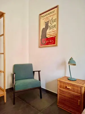 a room with a chair and a poster on the wall at Casa Sommeiller in Rome