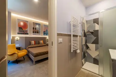 a small bedroom with a bed and a desk at GuestHost - Studio Apartment MM Cipro Rome in Rome