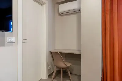 a room with a table and a chair and a desk at GuestHost - Studio Apartment MM Cipro Rome in Rome