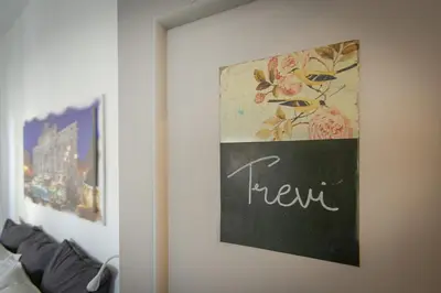 a chalkboard sign on a wall with a picture of flowers at BB Trastevere Station - Room2 in Rome