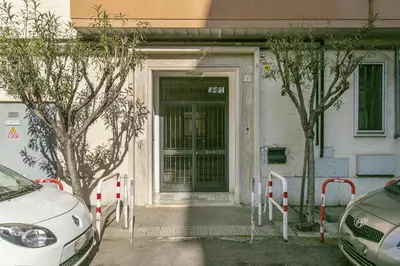 a door to a building with two cars parked outside at BB Trastevere Station - Room3 in Rome