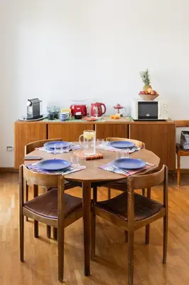 a kitchen with a wooden table and chairs in a room at Sempione-Metro B, Vintage Apartment, AC, WiFi in Rome