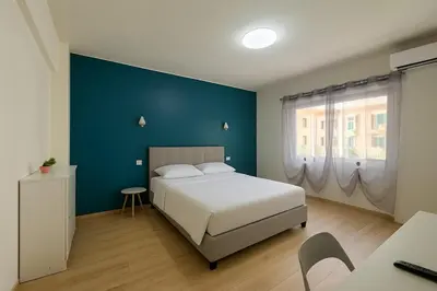 a bedroom with a white bed and a blue wall at Casa Emma in Rome
