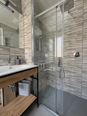 a bathroom with a glass shower and a sink at Casa Emma in Rome