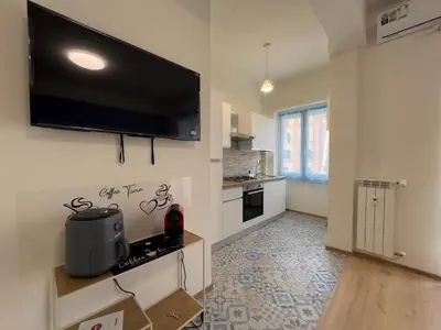 a kitchen with a flat screen tv on the wall at Casa Emma in Rome