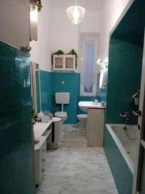 a bathroom with two toilets and a green wall at Casa di Andrea 2 in San Pietro in Rome
