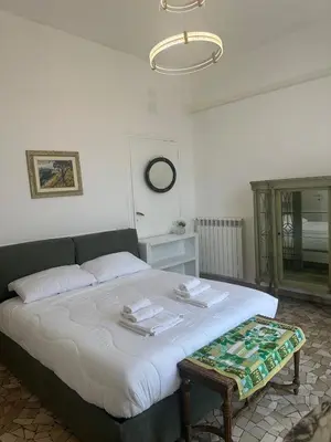a bedroom with a large bed with a table at Casa di Andrea 2 in San Pietro in Rome
