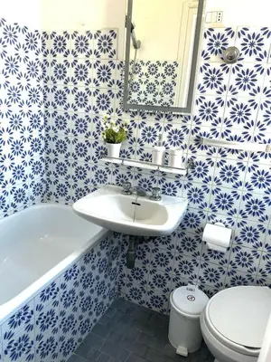a bathroom with blue and white tiles on the wall at Casa di Andrea 2 in San Pietro in Rome