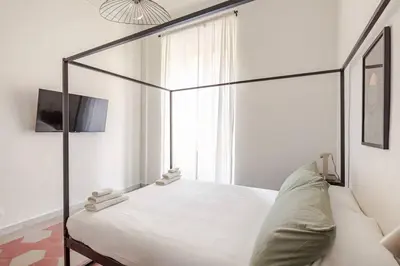a bedroom with a canopy bed and a window at RL Apartment in Rome