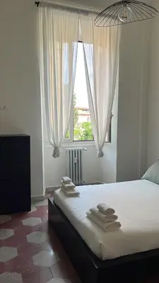 a bedroom with a bed with white sheets and a window at RL Apartment in Rome