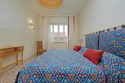 a bedroom with a bed with a blue and red comforter at Gioia's Home in Rome