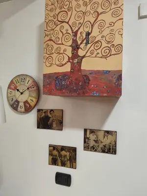 a clock on a wall with a picture of a tree at Next Stop St Peter - Apartment in Rome