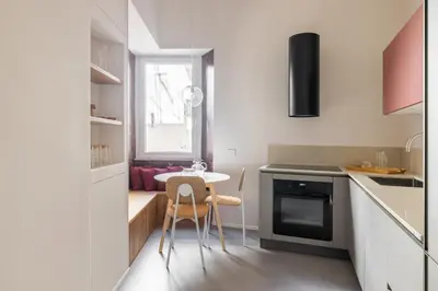 a small kitchen with a table and chairs in it at Stylish 3BR between Vatican & City Center in Rome