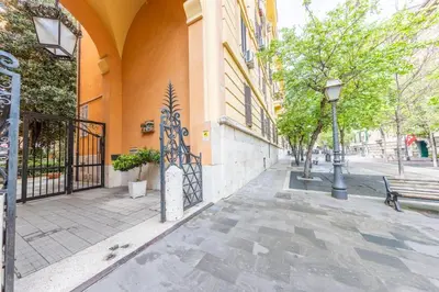 an empty street with a bench and a building at San Pietro View Boutique Rooms in Rome