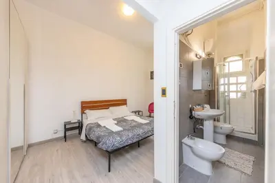 a bedroom with a bed and a sink and a toilet at San Pietro View Boutique Rooms in Rome