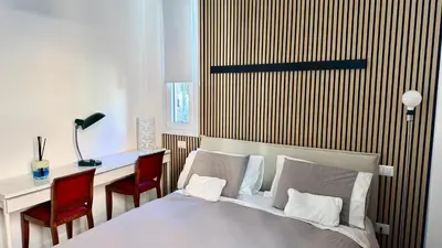 a bedroom with a bed and a desk with chairs at Elegant suite near the Vatican in Rome