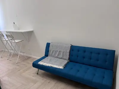 a blue couch in a living room with a table at Parthenope Vatican House in Rome