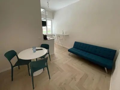 a living room with a blue couch and a table at Parthenope Vatican House in Rome