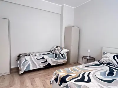 two beds in a room with white walls at Parthenope Vatican House in Rome