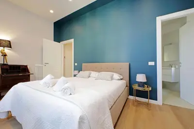 a bedroom with a large white bed with a blue wall at 4BNB - Flaminio Modern Apartment in Rome