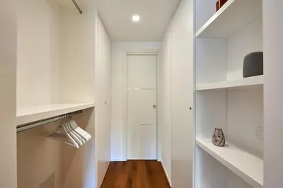 a white walk in closet with white shelves at Art Suite San Giovanni in Rome