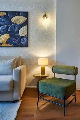 a living room with a couch and a chair and a lamp at Art Suite San Giovanni in Rome